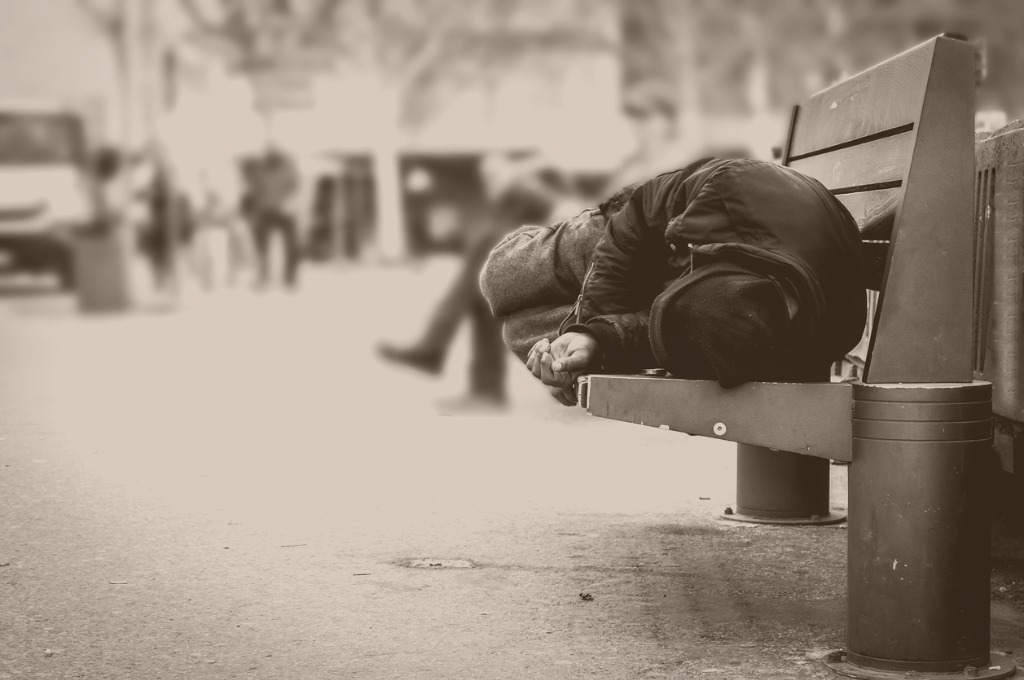 poor-homeless-man-or-refugee-sleeping-on-the-wooden-bench-on-the-in-picture-id929671484